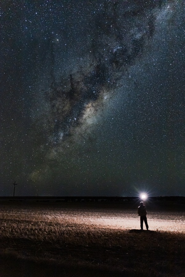Carel standing under the Milky Way on a dark open landscape